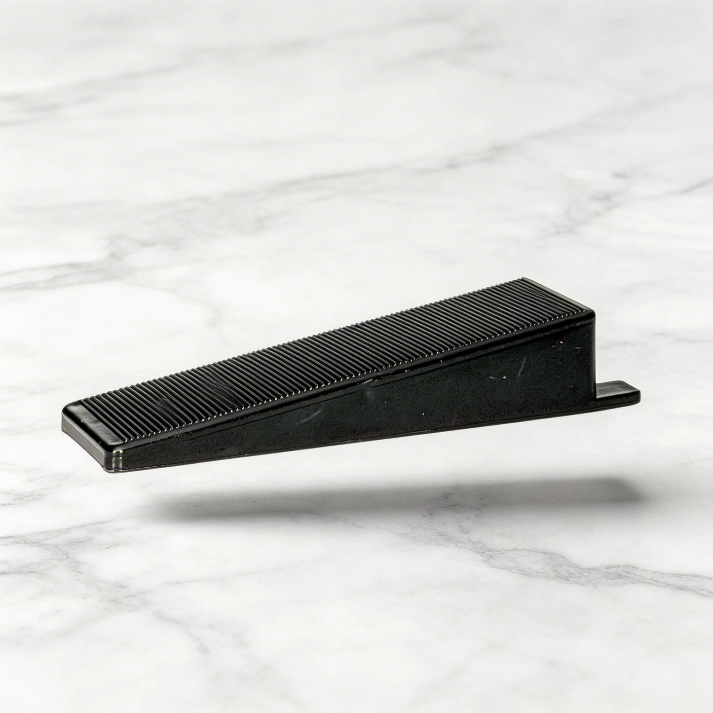 Oskita Civiplas tile leveling wedge on marble background
